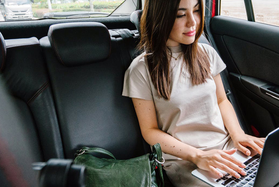 girl using laptop in taxi